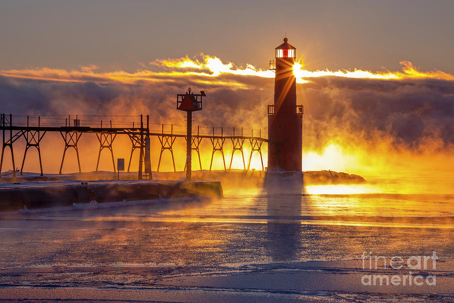 Dazzling Algoma Lighthouse with fog and icy harbor at sunrise ...