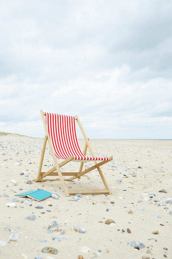 Deck Chair With Book On Sand At Beach Photograph by Dougal Waters