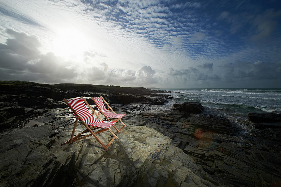 Deck Chairs On Rocky Coastline Photograph by Dougal Waters