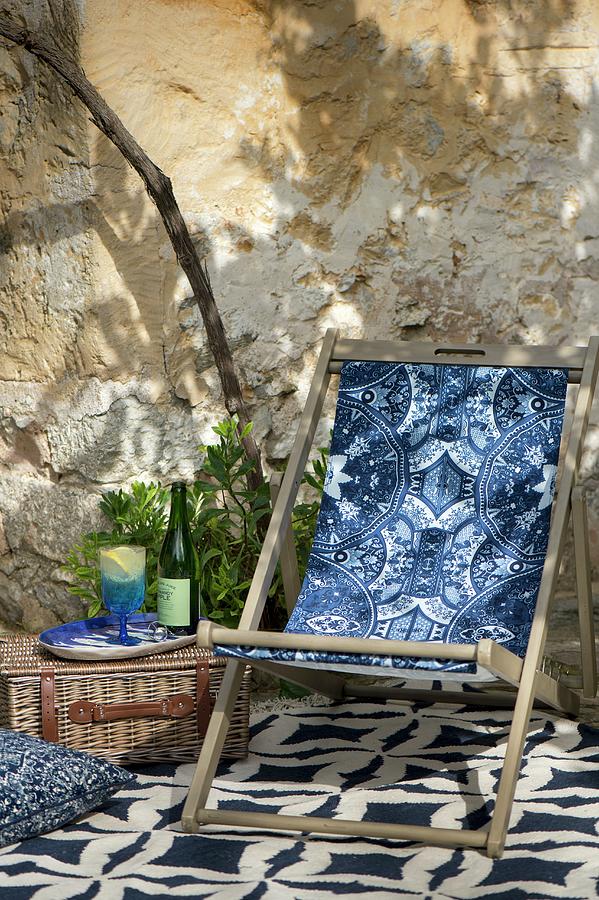 Deckchair And Blue Textiles In Summery Seating Area Photograph by Winfried Heinze