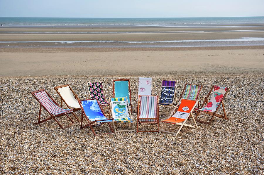 Deckchairs With Various Patterned Fabrics On A Beach With A View Of The Sea Photograph by Winfried Heinze
