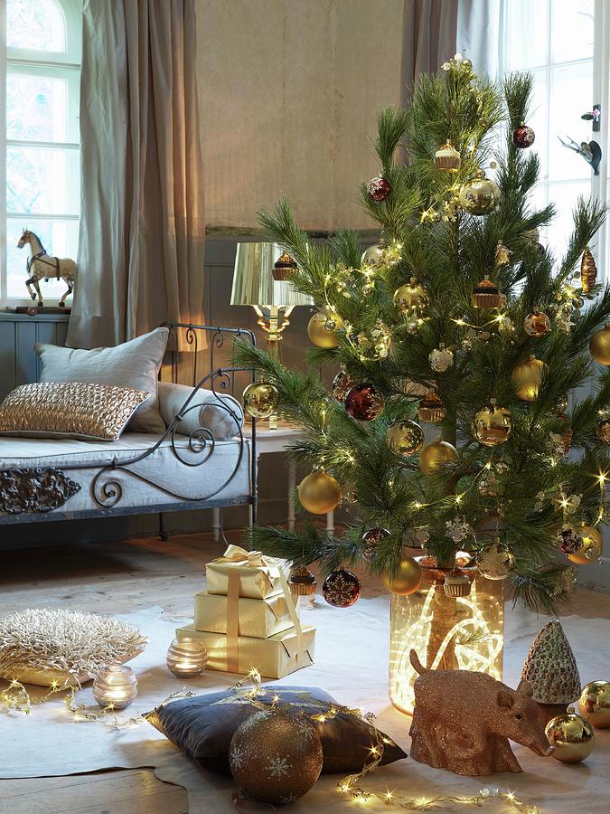 Decorated Christmas Tree And Presents On Floor In Front Of Bench With Metal Frame In Rustic Living Room Photograph by Matteo Manduzio