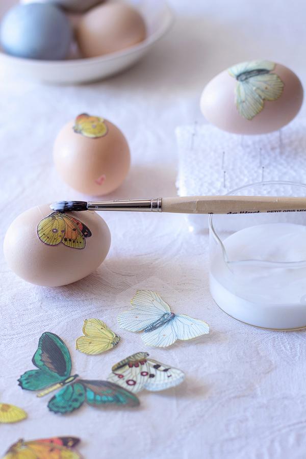 Decorating Eggs - Applying Decoupage Butterfly Motif Using Glue Photograph by Great Stock!