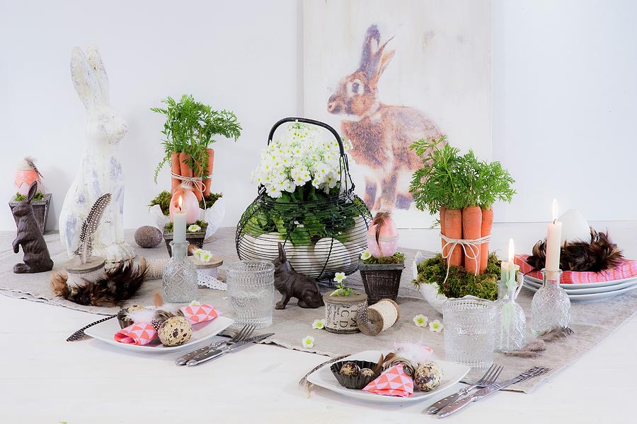 Decorative Flower Arrangements And Rabbit Figurines On Festively Set Easter Table Photograph by Bildhbsch