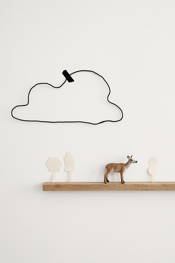 Deer Figurine And Cut-out Paper Trees On Narrow Floating Shelf Below Hand-crafted Wire Cloud Stuck To Wall With Washi Tape Photograph by James Stokes