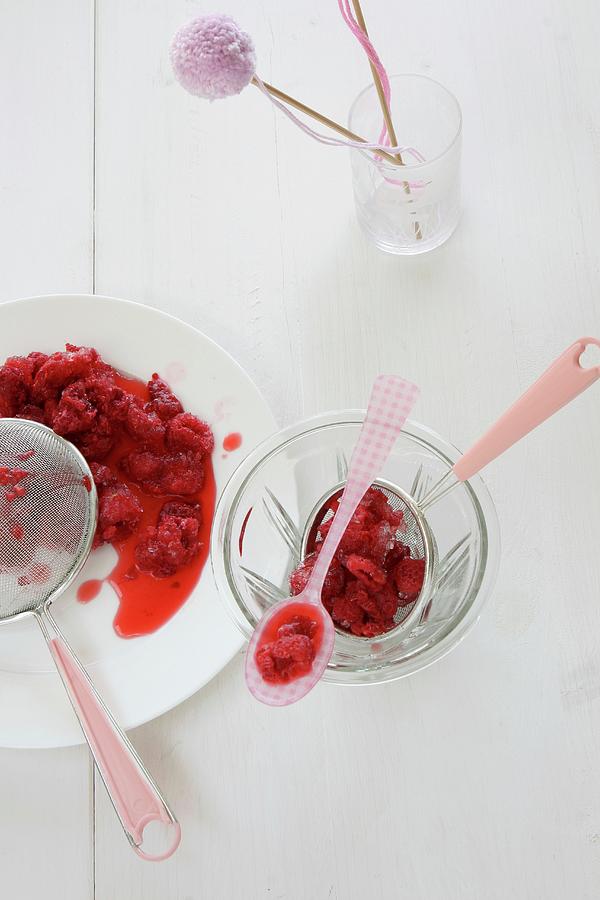 Defrosted Raspberries With A Sieve And A Plastic Spoon Photograph by Regina Hippel