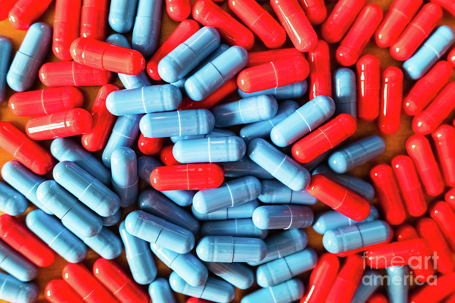 Detail of a handful of mixed red and blue pills. by Joaquin Corbalan - Pixels