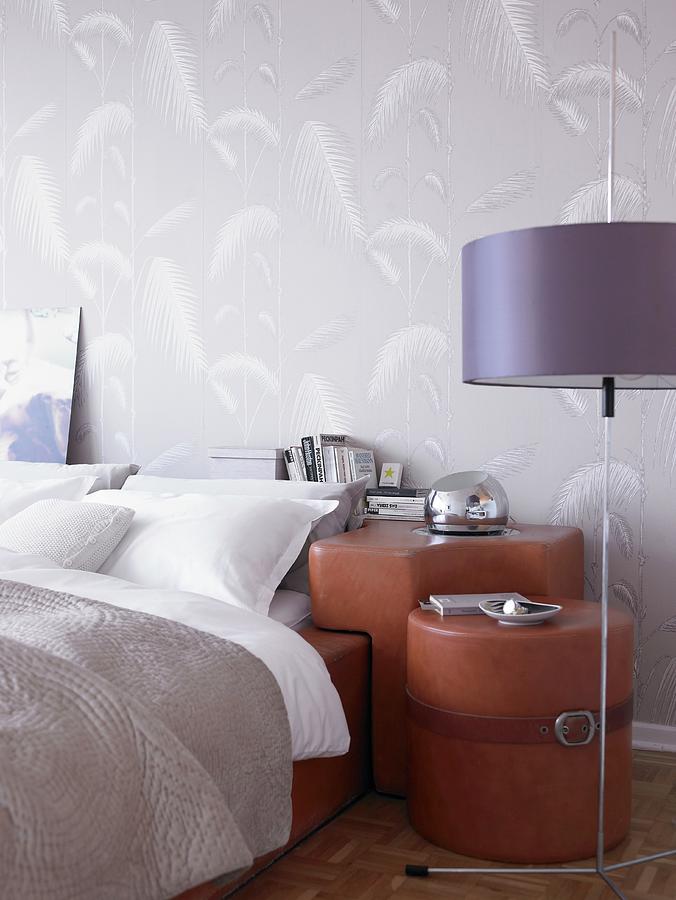 Detail Of Double Bed With Fitted, Custom-made Group Of Bedside Cabinets Covered In Brown Leather Against Wall With Pale Grey Patterned Wallpaper; Standard Lamp With Purple Lampshade In Foreground Photograph by Stefan Thurmann