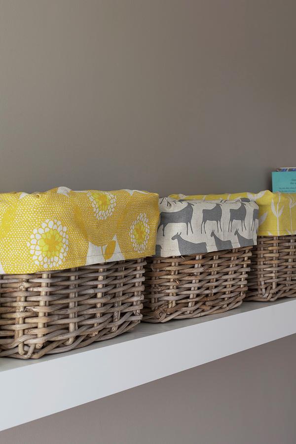 Detail Of Several Baskets Lined With Patterned Fabrics On White Shelf On Pale Grey Wall Photograph by Great Stock!