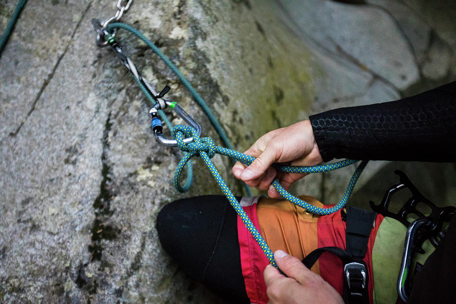 Detail View Of Climber Tying Rope For Rappel, Bolted Route In Canyon