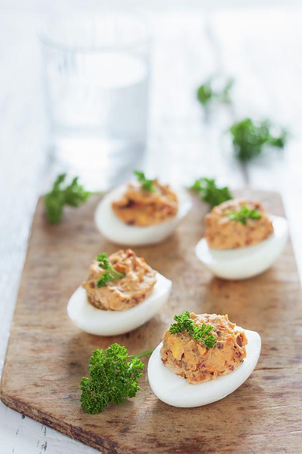 Devilled Eggs With Dried Tomatoes And Fresh Parsley On A Wooden Board Photograph by Malgorzata Laniak