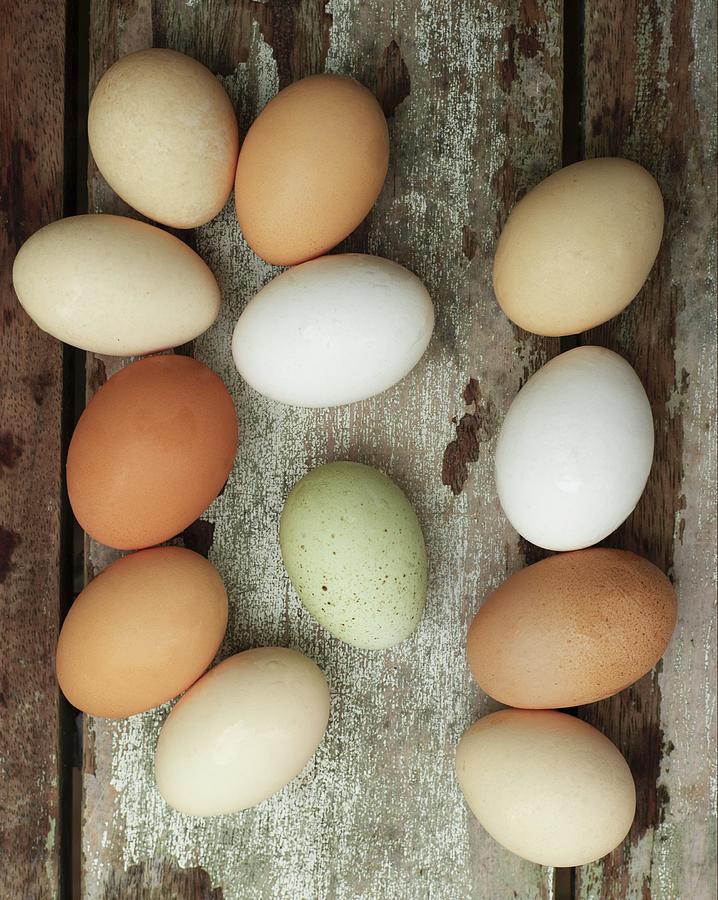 Different-coloured Fresh Eggs On A Wooden Background Photograph by Anna Huerta