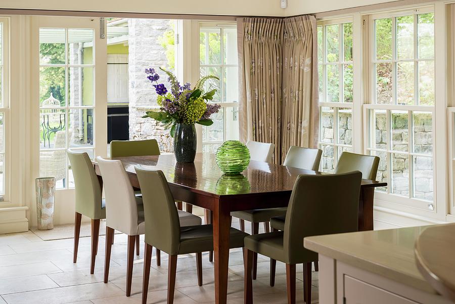 Dining Area In Conservatory With Lattice Windows, Wooden Table And Upholstered Chairs With Various Covers Photograph by Brian Harrison