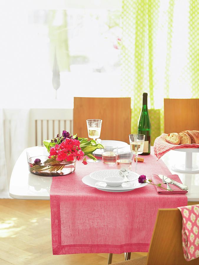 Dining Table With Pink Table Cloth, Flowers In Bowl And White Wine Photograph by Jalag / Julia Hoersch