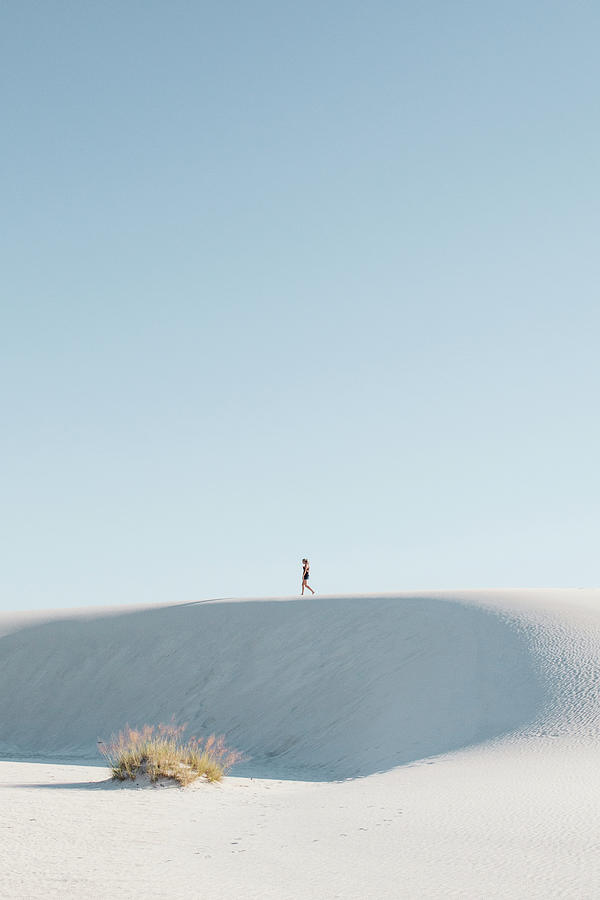 White Sands National Monument Photograph - Distant View Of Woman Walking At White Sands National Monument Against Clear Sky by Cavan Images