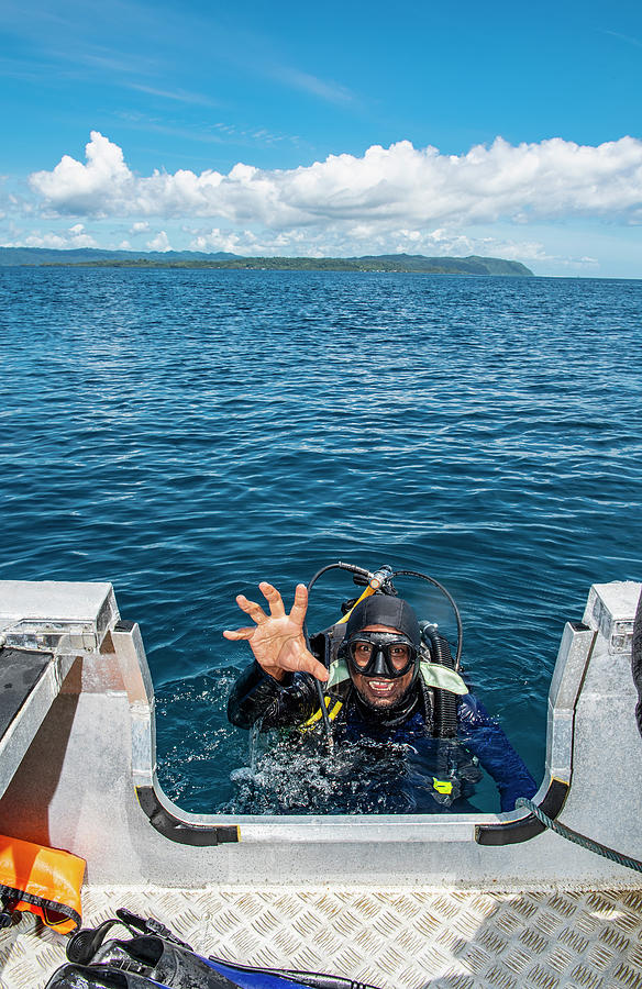 Diver Reaching To Dingy After Returning To The Surface In Raja Ampat ...