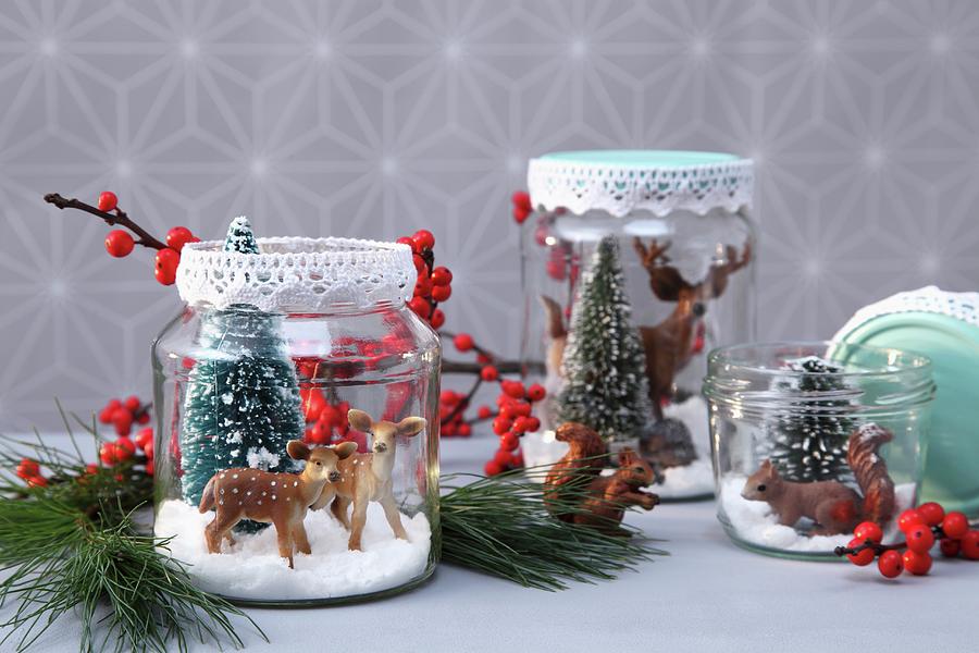 Diy Christmas Arrangement Of Plastic Animals And Plastic Fir Trees In Jam Jars Decorated With Lace Trim Photograph by Thordis Rggeberg