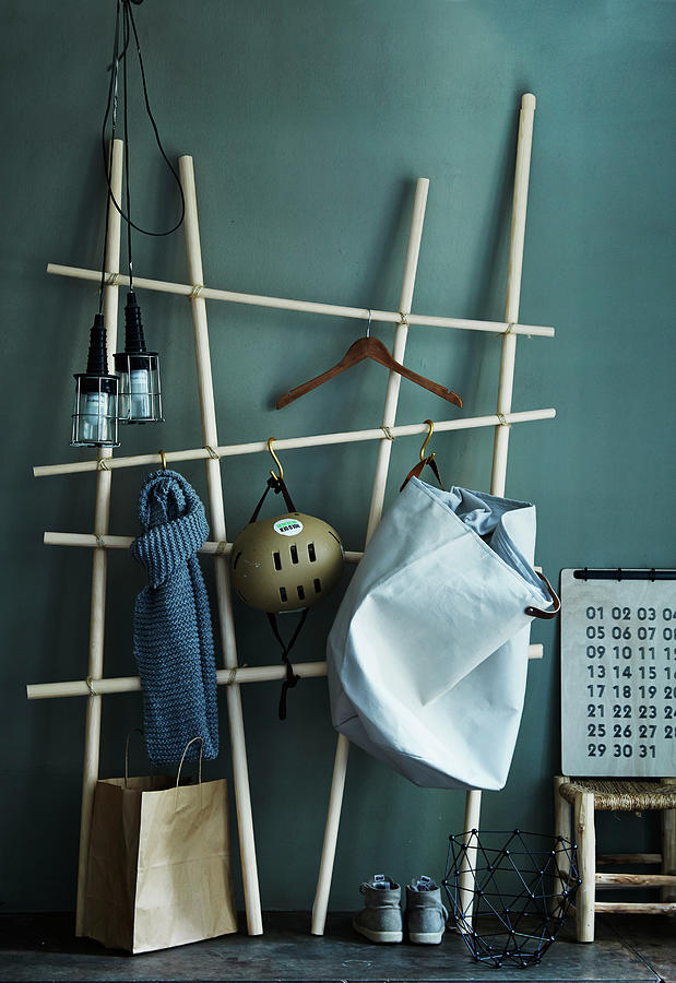 Diy Coat Rack Made From Wooden Poles And Butchers Hooks Against Green-grey Wall Photograph by Nicoline Olsen