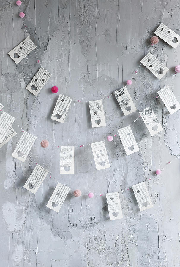 Diy Garlands Made From Book Pages With Punched Heart Motifs And Pompoms Photograph by Thordis Rggeberg