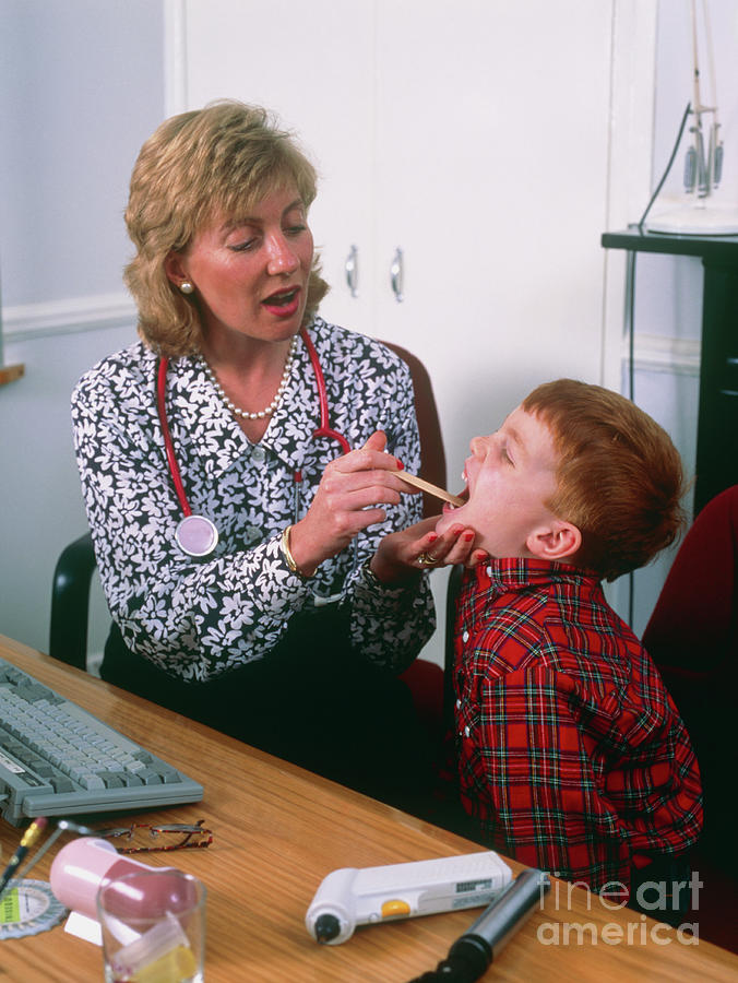 Doctor Examining The Throat Of Small Boy Photograph by Mark Clarke/science Photo Library