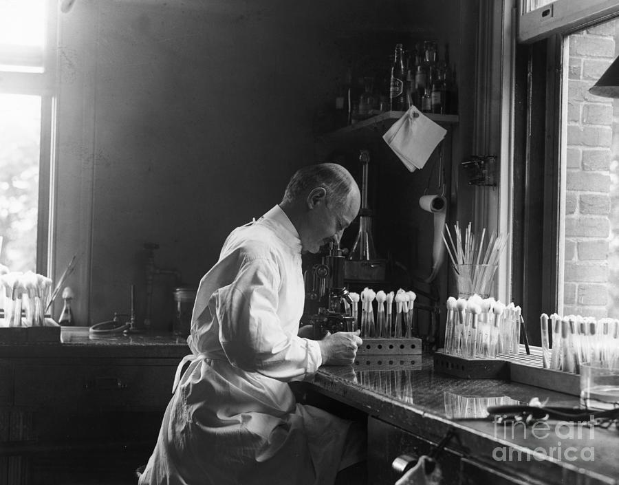 Doctor Looking Through Microscope Photograph by Bettmann Doctor Looking Through Microscope Photograph by Bettmann