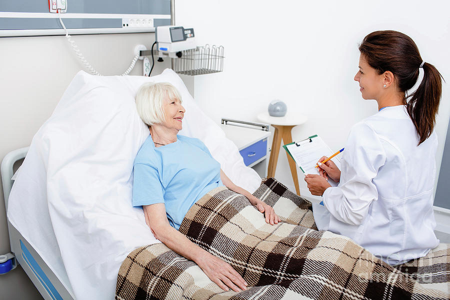 Doctor Talking To Senior Woman On Hospital Ward Photograph by Peakstock / Science Photo Library