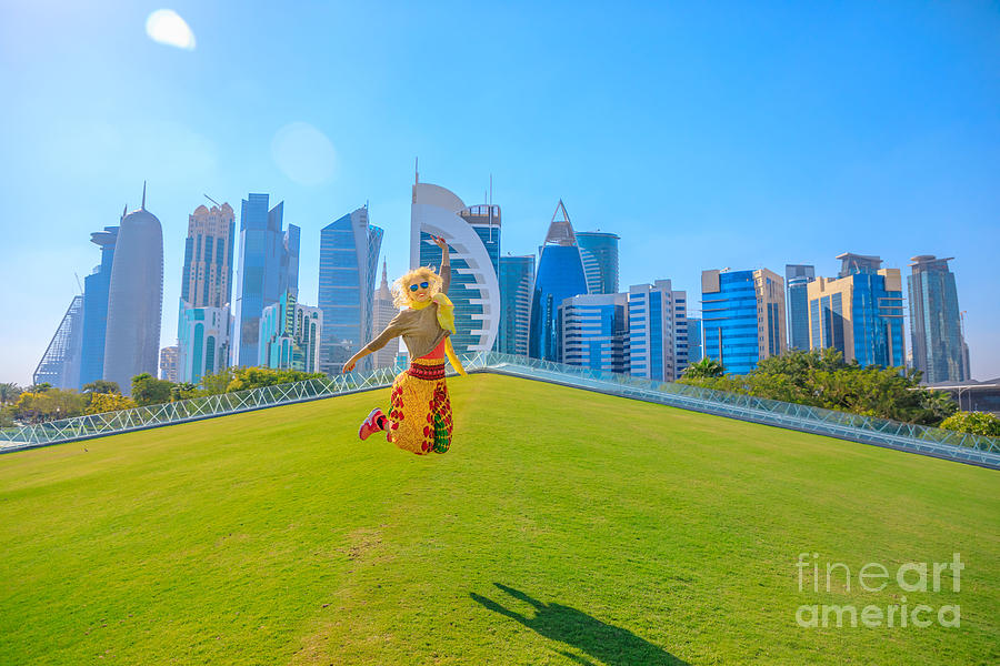 Doha skyline woman jumping Photograph by Benny Marty