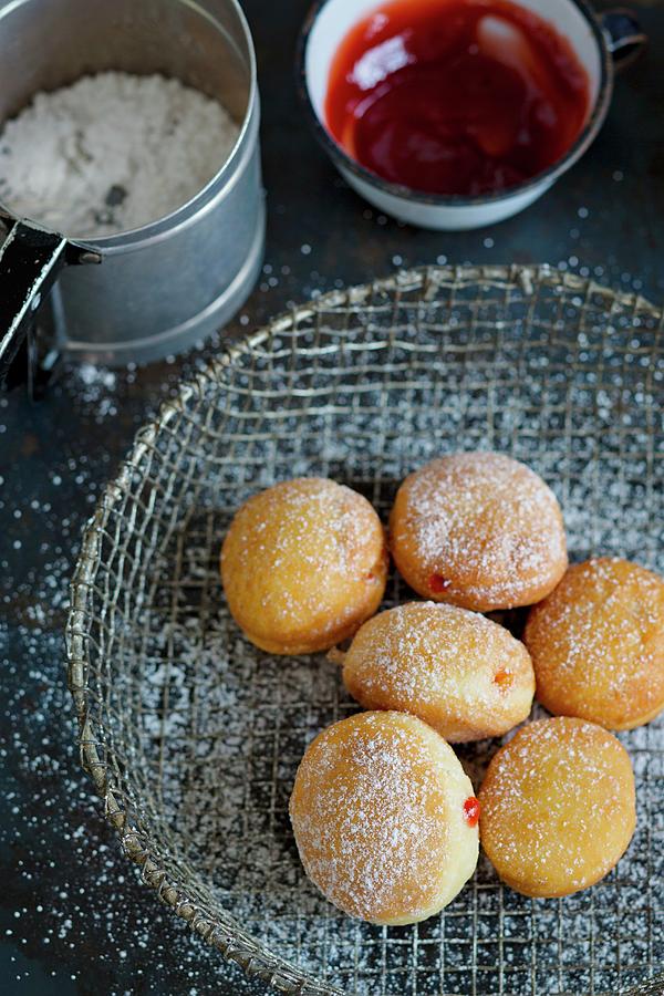 Donuts In A Wire Basket, A Cup Of Jam And A Can Of Icing Sugar Photograph by Tina Engel