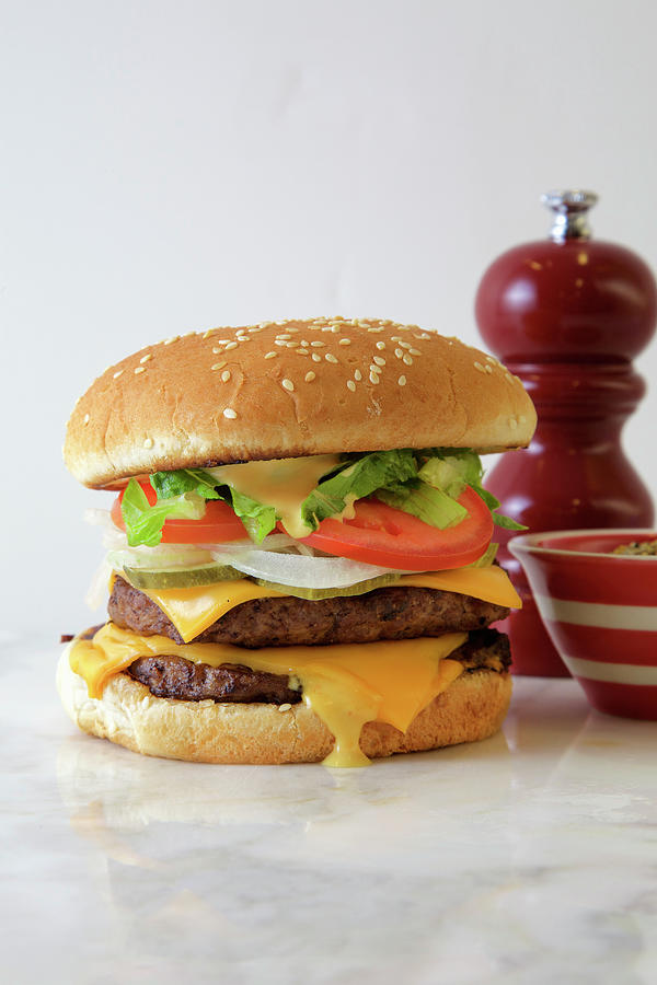 Double Burger With American Cheese, Lettuce And Tomato On A White Background, With Extra Spices Photograph by Andre Baranowski