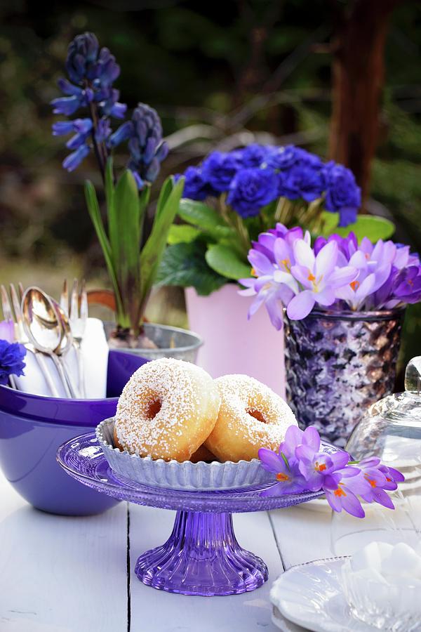 Doughnuts On A Table Outside Decorated With Crockery And Blue And Purple And Flowers Photograph by Angelica Linnhoff