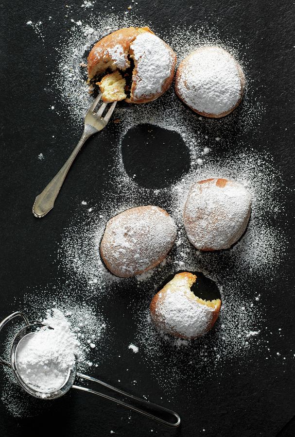 Doughnuts With Icing Sugar On A Black Surface Photograph by Martin Dyrlv
