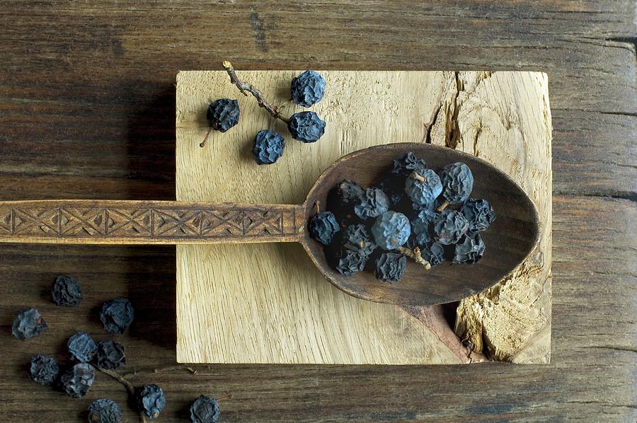 Dried Blackthorn Fruits On A Wooden Spoon Photograph by Achim Sass