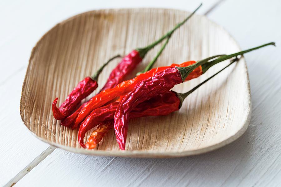 Dried Chilli Peppers In A Bamboo Bowl Photograph by Nicole Godt