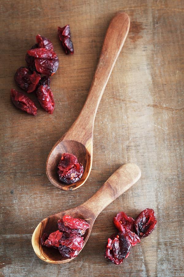Dried Cranberries And Two Wooden Spoons Photograph by Eva Grndemann