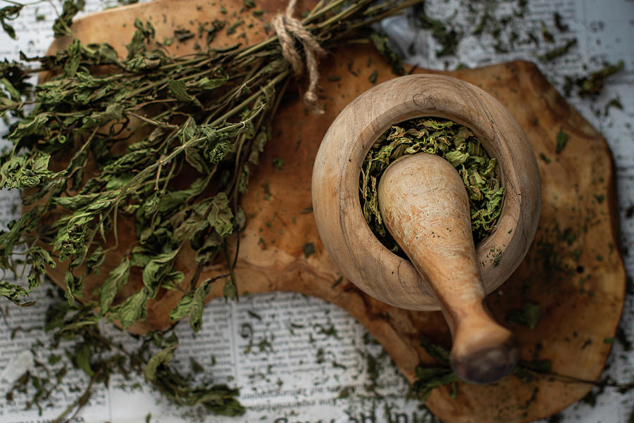 Dried Mint In An Olive Wood Mortar On A Wooden Board On Newspaper Photograph by Myriam Meliani