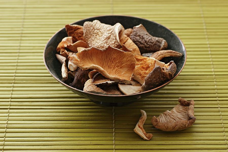 Dried Oyster Mushrooms In A Bowl On A Bamboo Mat Photograph by Gross, Petr