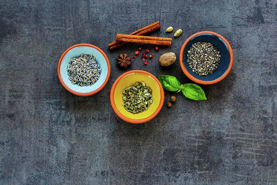 Dry Tasty Herbs And Spices In Pinch Bowls On Dark Concrete Background Photograph by Yuliya Gontar