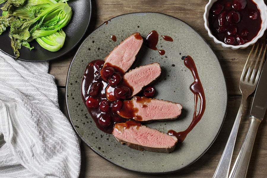 Duck Breast With Sour Cherry Sauce And Bok Choy Photograph by Nicole Godt