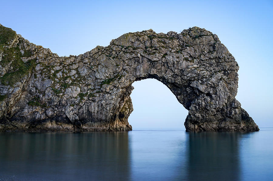 Durdle door in England seen at blue hour. Photograph by George Afostovremea