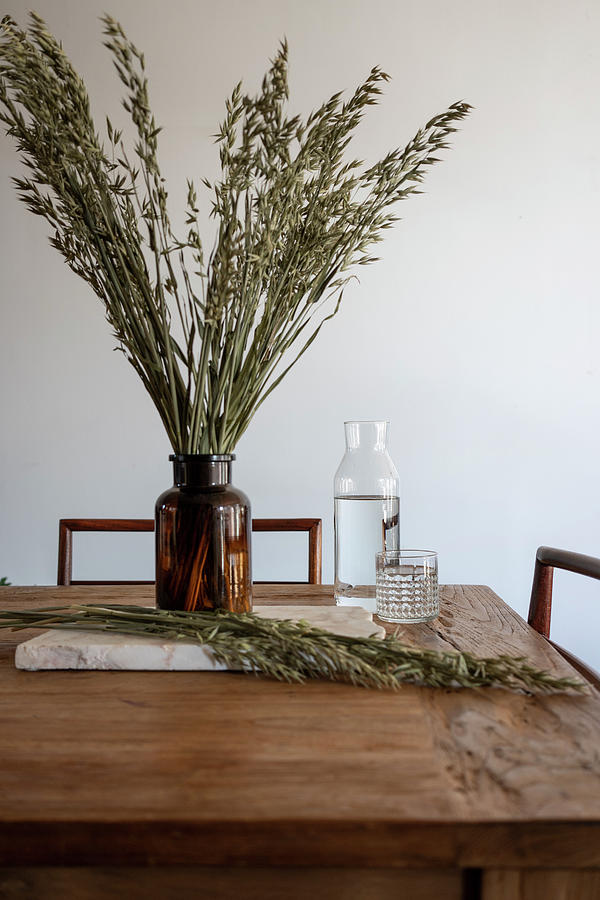 Ears Of Cereal In Apothecary Bottle And Glass Carafe On Rustic Wooden Table Photograph by Barbara Cilliers