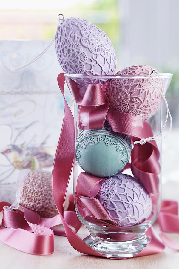 Easter Arrangement Of Ceramic Eggs With Various Lacy Patterns And Satin Ribbon In Glass Vase Photograph by Franziska Taube