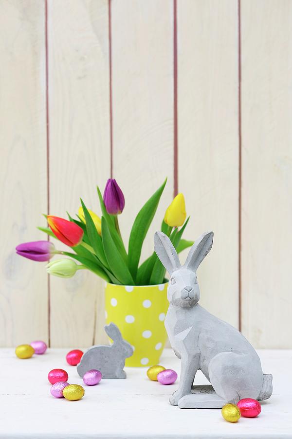 Easter Arrangement Of Concrete Rabbit Ornament And Vase Of Multicoloured Tulips Photograph by Thordis Rggeberg