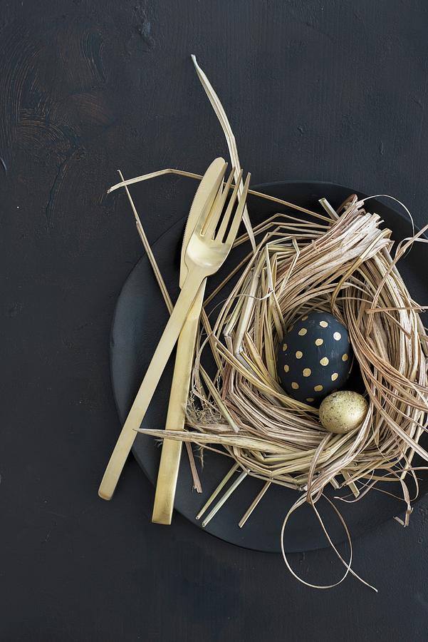 Easter Arrangement Of Gold And Black Eggs In Nest And Gold Cutlery On Black Plate Photograph by Ulla@patsy