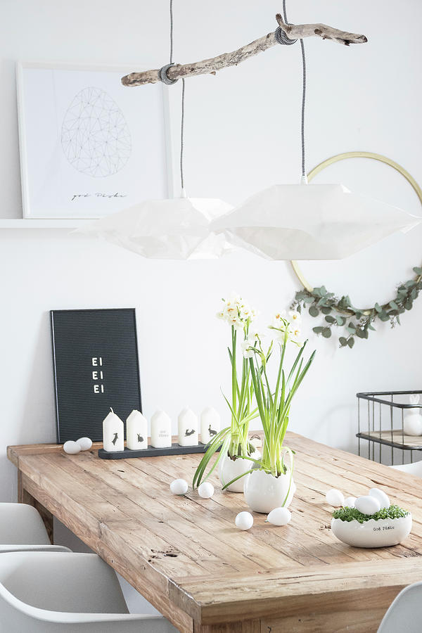 Easter Arrangement On Wooden Table: Candles, Narcissus And White Eggs In Cress Nest Photograph by Astrid Algermissen