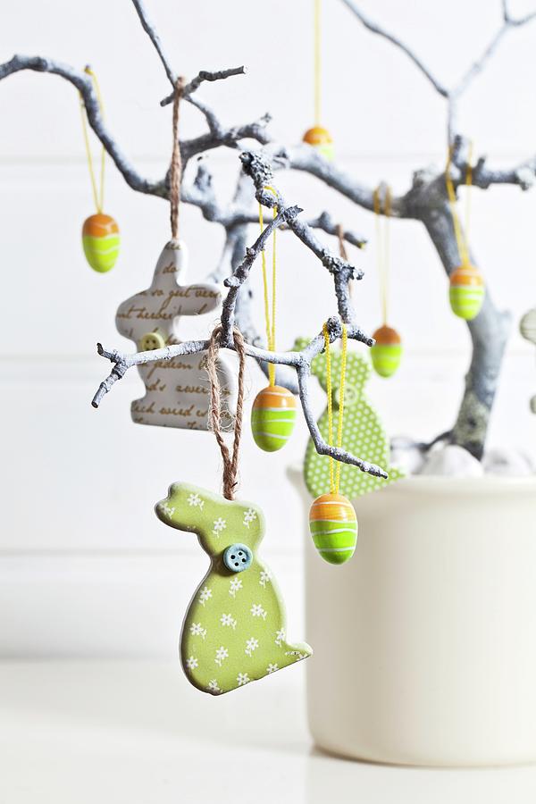 Easter Arrangement With Rabbits And Eggs Hanging From Branch Photograph by Uwe Merkel