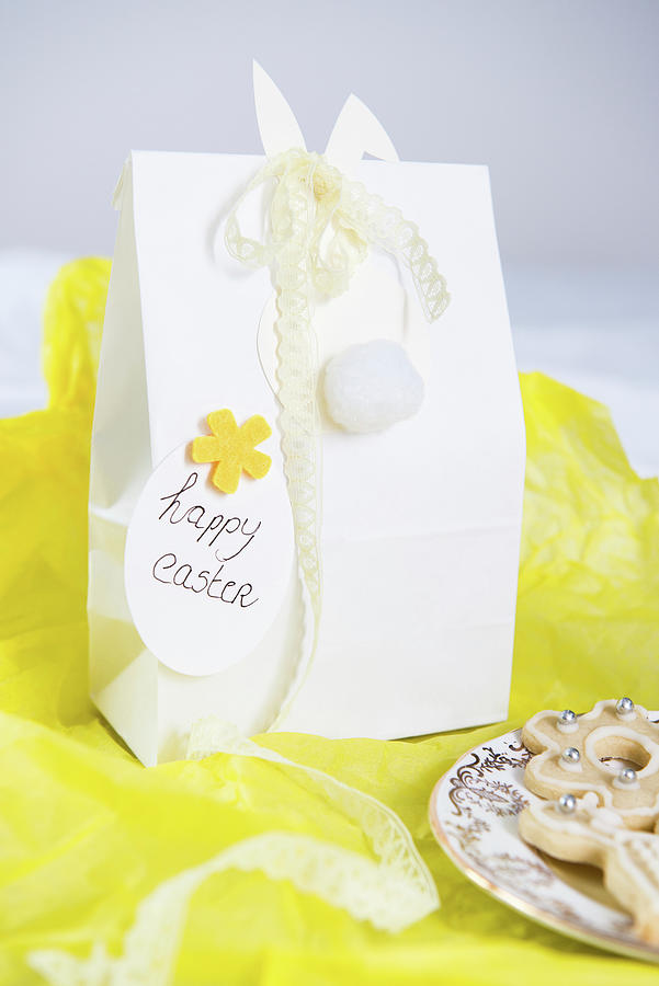 Easter Bunny With Lace Ribbon On Gift Bag On Yellow Tissue Paper Photograph by Ruud Pos