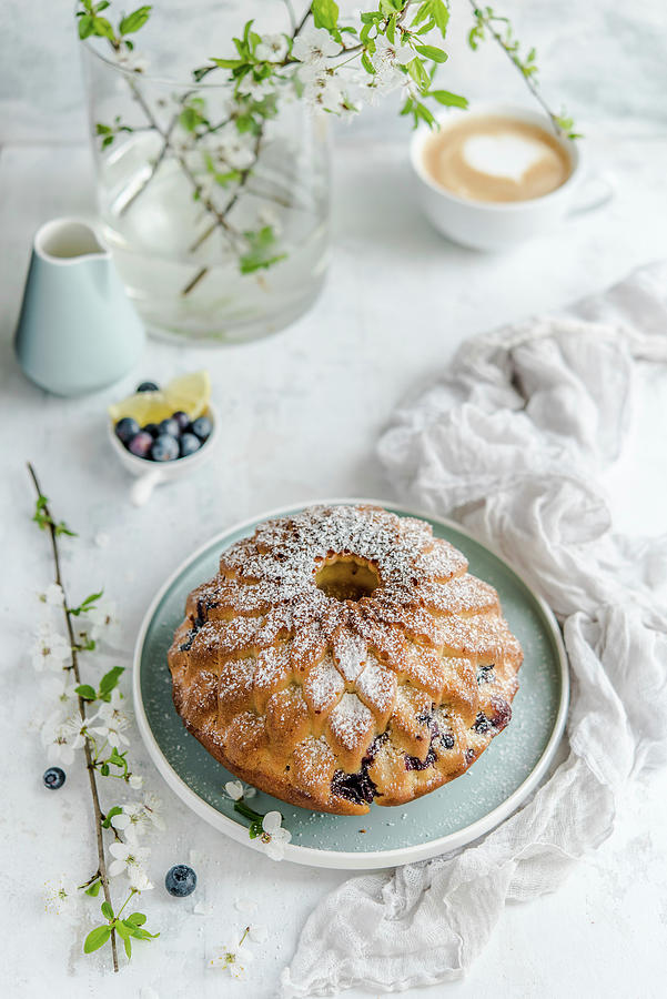 Easter Cake With Blueberries And Lemon, Sprinkled With Powdered Sugar, Coffee On The Background Photograph by Diana Kowalczyk