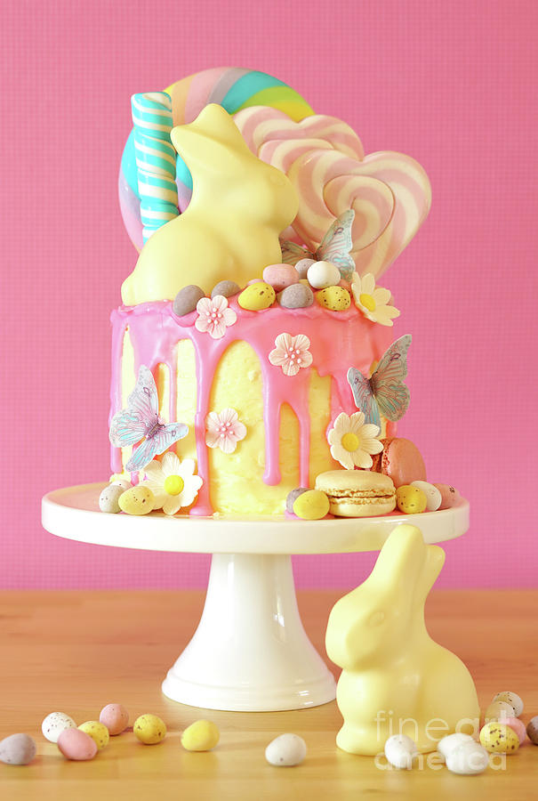 Easter candy land drip cake decorated with lollipops and white bunny. Photograph by Milleflore Images