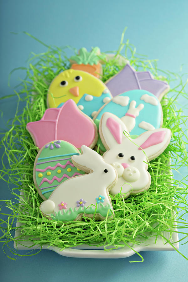 Easter Cookies, Bunnies And Eggs On White Plate With Decorative Grass Photograph by Elena Veselova