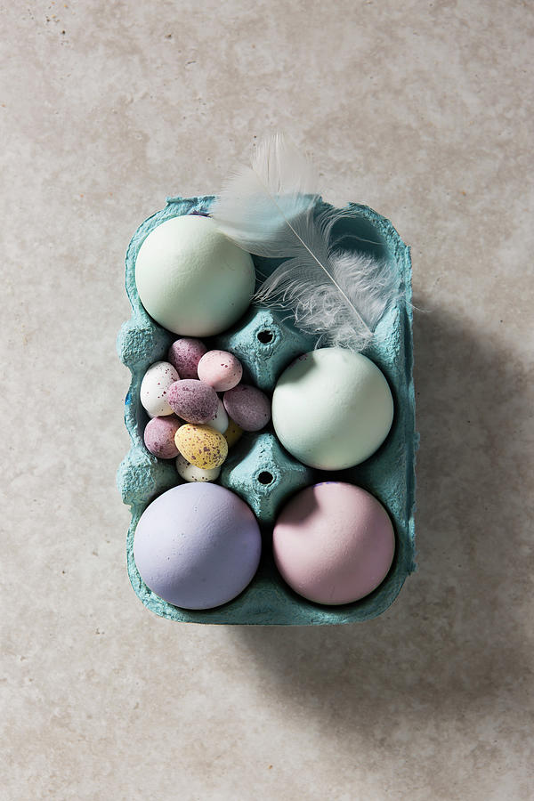 Easter Dyed Eggs In A Box With Chcolate Mini Eggs, Overhead With A White Feather Photograph by Stacy Grant